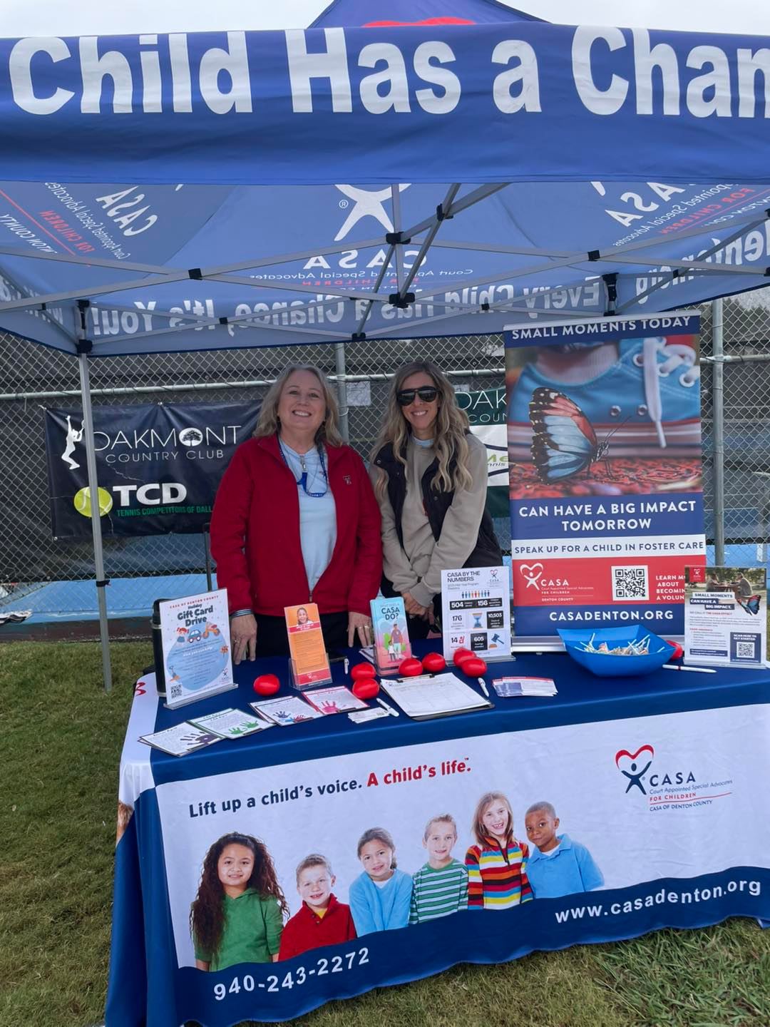 Outdoor event booth with a custom printed CASA tent, table cover, and banner